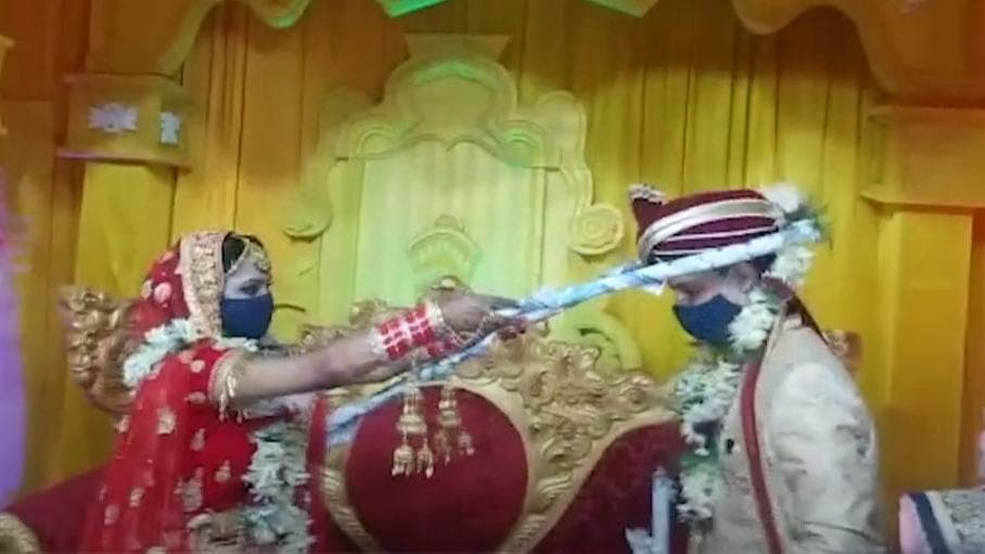 कोरोनावायरस का साइड इफेक्ट: दूल्हा-दुल्हन ने डंडे से पहनाई जयमाला